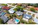 Aerial view of a neighborhood showing a home with a pool surrounded by other houses and tree-lined streets at 1400 63Rd S Ave, St Petersburg, FL 33705