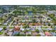 Extensive aerial view of a community showcasing tree-lined streets, varied home styles, and recreational areas at 1400 63Rd S Ave, St Petersburg, FL 33705