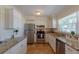 Bright kitchen featuring stainless steel appliances, granite countertops, white cabinets, and tile flooring at 1400 63Rd S Ave, St Petersburg, FL 33705