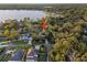 Aerial view of the home on a lot with mature trees and a lake in the distance at 14825 Lake Magdalene Cir, Tampa, FL 33613