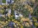 An aerial view of a home amongst lush trees near other houses, showcasing the neighborhood at 14825 Lake Magdalene Cir, Tampa, FL 33613