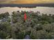 Aerial shot of a house on a tree-filled lot near a lake at sunset at 14825 Lake Magdalene Cir, Tampa, FL 33613