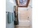 Bright bathroom featuring a bathtub with shower, tile surround, and a charming skylight allowing natural light at 14825 Lake Magdalene Cir, Tampa, FL 33613