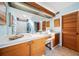 Well lit bathroom with double vanity, wood cabinets, and skylight at 14825 Lake Magdalene Cir, Tampa, FL 33613
