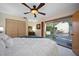Bedroom with a large bed, ceiling fan, and sliding door to an outdoor patio with outdoor seating at 14825 Lake Magdalene Cir, Tampa, FL 33613