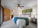 Bedroom featuring a king bed, ceiling fan, and windows offering lots of natural light with an open doorway to hallway at 14825 Lake Magdalene Cir, Tampa, FL 33613