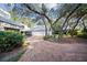 Driveway leading to a spacious three-car garage, surrounded by lush greenery at 14825 Lake Magdalene Cir, Tampa, FL 33613