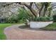 Charming brick driveway with address marker surrounded by lush landscaping at 14825 Lake Magdalene Cir, Tampa, FL 33613