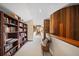 Hallway featuring a built-in bookshelf, hardwood accents, and a view leading to the home's interior at 14825 Lake Magdalene Cir, Tampa, FL 33613