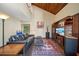 A comfortable living room with unique ceiling architecture, brick floors, and large TV at 14825 Lake Magdalene Cir, Tampa, FL 33613