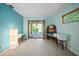 Light-filled living room with blue walls, large sliding glass doors to outdoor deck, and neutral-toned carpet at 14825 Lake Magdalene Cir, Tampa, FL 33613