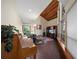 Living room featuring brick flooring, wooden ceilings, large bright windows, and custom piano at 14825 Lake Magdalene Cir, Tampa, FL 33613