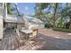 Outdoor patio area with a wooden deck, a grill and table with chairs near the garage at 14825 Lake Magdalene Cir, Tampa, FL 33613