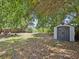 Secluded backyard with storage shed, a firepit area, mature trees, and partial fencing at 173 21St Se Ter, Largo, FL 33771