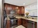 Modern kitchen with stainless steel appliances, granite countertops, and dark wood cabinets at 173 21St Se Ter, Largo, FL 33771