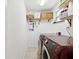 Functional laundry area with a red washer and dryer set, storage shelves, and an energy-efficient water heater at 173 21St Se Ter, Largo, FL 33771