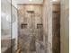 Modern shower with stylish stone tile, built-in niche, river rock accent, and rainfall showerhead at 173 21St Se Ter, Largo, FL 33771