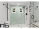 Bright bathroom featuring light-green subway tiles, modern fixtures, and a seamless glass shower enclosure at 2033 Arbor Dr, Clearwater, FL 33760