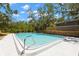 This spacious pool is surrounded by lush greenery, trees, and wooden decking and steps offering the perfect outdoor oasis at 2033 Arbor Dr, Clearwater, FL 33760