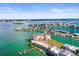 Wide aerial view of a waterfront condo with docks, surrounded by beautiful turquoise water at 205 Brightwater Dr # 101, Clearwater Beach, FL 33767