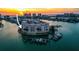 Sunset aerial view of a waterfront condo building surrounded by water and docks at 205 Brightwater Dr # 101, Clearwater Beach, FL 33767