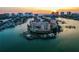 Aerial view of a waterfront condo building with boat docks, set against the picturesque Intracoastal Waterway at sunset at 205 Brightwater Dr # 101, Clearwater Beach, FL 33767