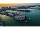 Stunning aerial view of waterfront condo building with private boat docks and Intracoastal Waterway views at sunset at 205 Brightwater Dr # 101, Clearwater Beach, FL 33767