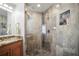 Bathroom with a stone tiled shower, glass door, and a granite countertop vanity at 205 Brightwater Dr # 101, Clearwater Beach, FL 33767
