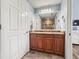 Bathroom with granite countertop, wooden cabinets, and a large mirror reflecting the shower at 205 Brightwater Dr # 101, Clearwater Beach, FL 33767