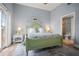 Bright bedroom with a green bed frame, neutral walls and a door leading to the bathroom at 205 Brightwater Dr # 101, Clearwater Beach, FL 33767