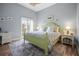 Bedroom with light walls, wooden floors, and a comfortable bed with a decorative rug at 205 Brightwater Dr # 101, Clearwater Beach, FL 33767