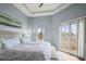 Cozy bedroom showcasing a tray ceiling, access to a balcony, a water view, and comfortable furnishings at 205 Brightwater Dr # 101, Clearwater Beach, FL 33767