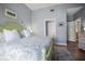 Comfortable bedroom with pale blue walls, green accents, and light wood floors at 205 Brightwater Dr # 101, Clearwater Beach, FL 33767