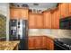 A kitchen offers stainless steel appliances, wooden cabinets, mosaic tile backsplash and granite countertops at 205 Brightwater Dr # 101, Clearwater Beach, FL 33767