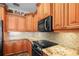 Kitchen features a backsplash, stainless steel appliances and granite countertops and cherry wood cabinets at 205 Brightwater Dr # 101, Clearwater Beach, FL 33767
