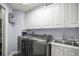 Well-lit laundry room featuring modern washer and dryer units, and ample cabinet space at 205 Brightwater Dr # 101, Clearwater Beach, FL 33767