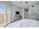 Serene main bedroom with private balcony, ceiling fan, tray ceiling, and ample natural light at 205 Brightwater Dr # 101, Clearwater Beach, FL 33767
