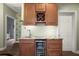 Custom wet bar with granite countertop, a wine rack, a beverage cooler, and ample cabinet storage at 205 Brightwater Dr # 101, Clearwater Beach, FL 33767