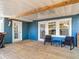 Covered back porch features wood flooring, stylish seating, and lots of light at 207 W Chelsea St, Tampa, FL 33603