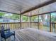 A covered back porch with wood floors, railing and steps down to the yard at 207 W Chelsea St, Tampa, FL 33603