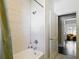 Bright bathroom with white subway tile surround in tub/shower with modern fixtures and nearby doorway at 207 W Chelsea St, Tampa, FL 33603