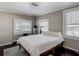 Cozy bedroom featuring a queen-size bed, dark wood floors, and natural light from three windows at 207 W Chelsea St, Tampa, FL 33603
