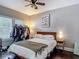Sunlit bedroom with hardwood floors, ceiling fan, and a comfortable bed with a throw blanket at 207 W Chelsea St, Tampa, FL 33603