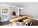 Dining room featuring a long wooden table, stylish chairs, and hardwood floors with open view to living room at 207 W Chelsea St, Tampa, FL 33603