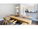 Bright dining room featuring a long wooden table, stylish chairs, hardwood floors, and view to the kitchen at 207 W Chelsea St, Tampa, FL 33603