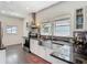 Sunlit kitchen features stainless appliances, undermount sink, black countertops, and a modern range hood at 207 W Chelsea St, Tampa, FL 33603