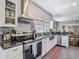 Modern kitchen with stainless steel appliances, granite countertops, white cabinetry, and an open dining area at 207 W Chelsea St, Tampa, FL 33603