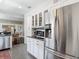 Modern kitchen featuring stainless steel appliances, white cabinetry, granite countertops, and an open dining area at 207 W Chelsea St, Tampa, FL 33603