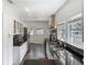 Well-lit kitchen featuring stainless steel appliances, granite countertops, white cabinetry, and wood-look flooring at 207 W Chelsea St, Tampa, FL 33603