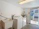 Bright laundry room with white washer, dryer, utility sink and access to the outside at 207 W Chelsea St, Tampa, FL 33603